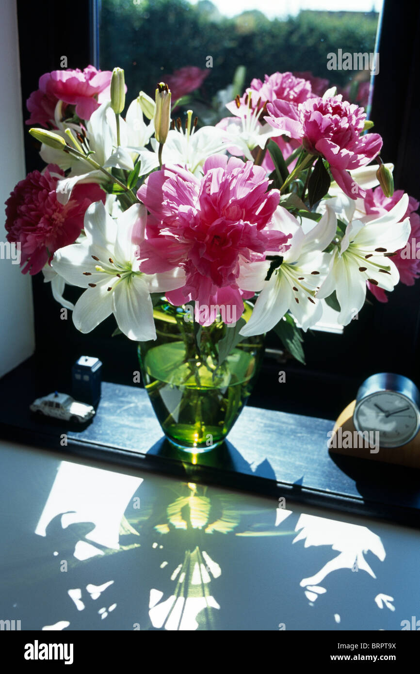 StillLife of pink and white lilies in glass vase on windowsill Stock