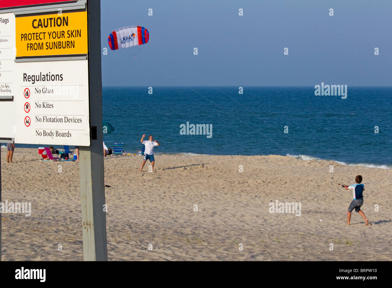 Family flies a kite on the beach despite sign stating no kite flying Stock Photo Alamy