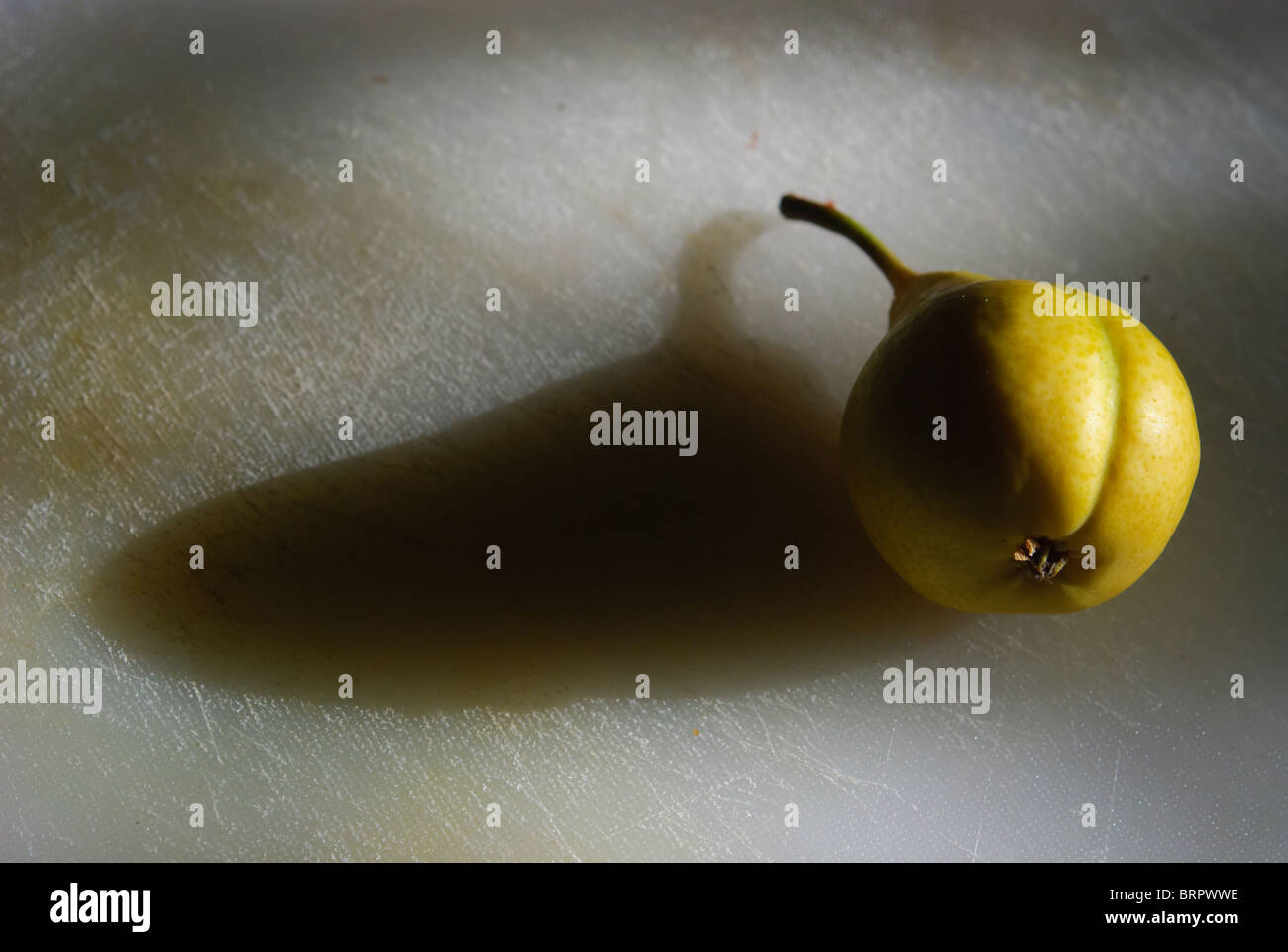 Pear in a tabletop food arrangement with strong light and shadow Stock ...
