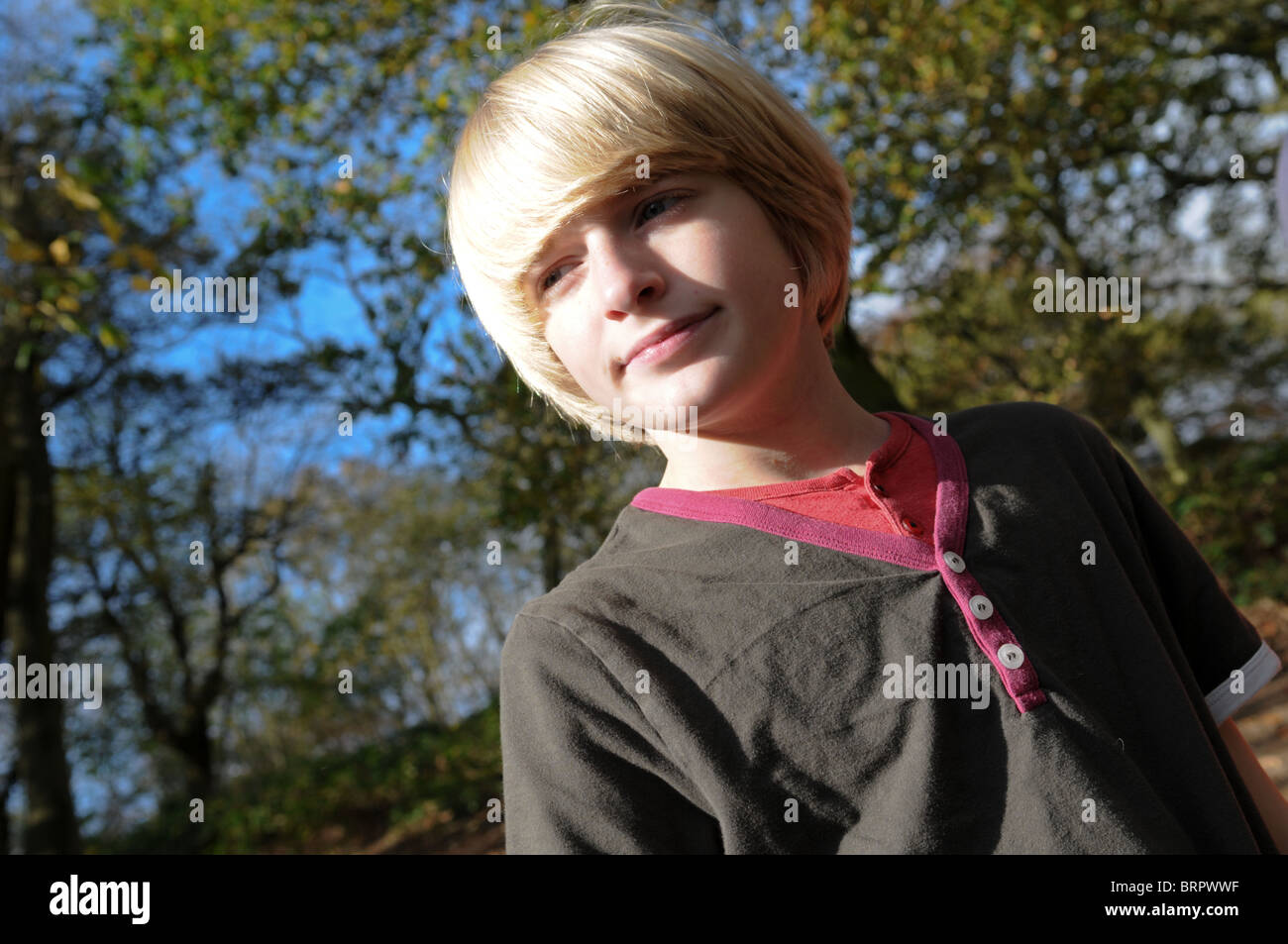 Blondhaired twelveyearold boy with pale skin looking wistfully into