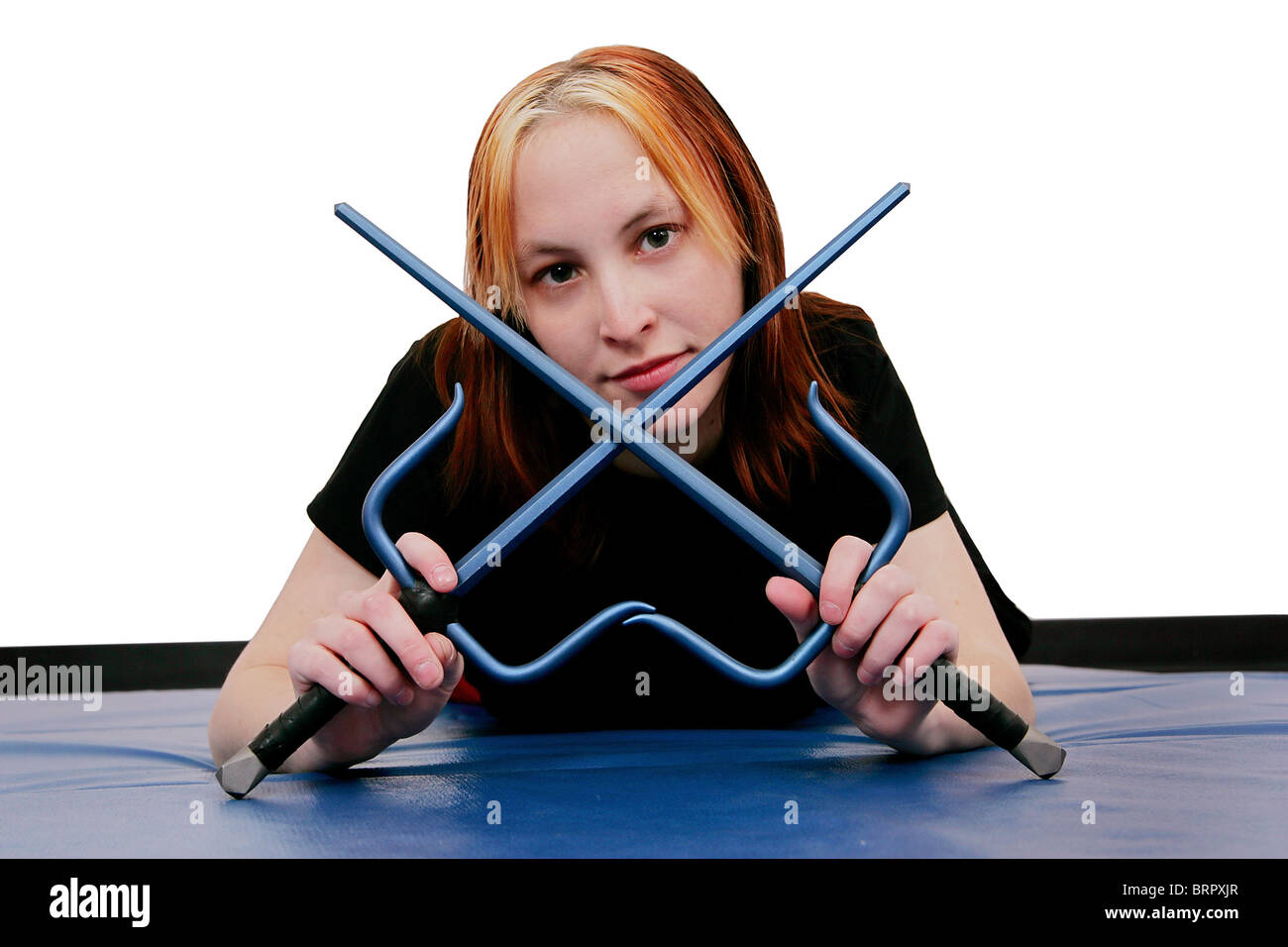 beautiful MMA young woman ready with crossed sai weapons Stock Photo