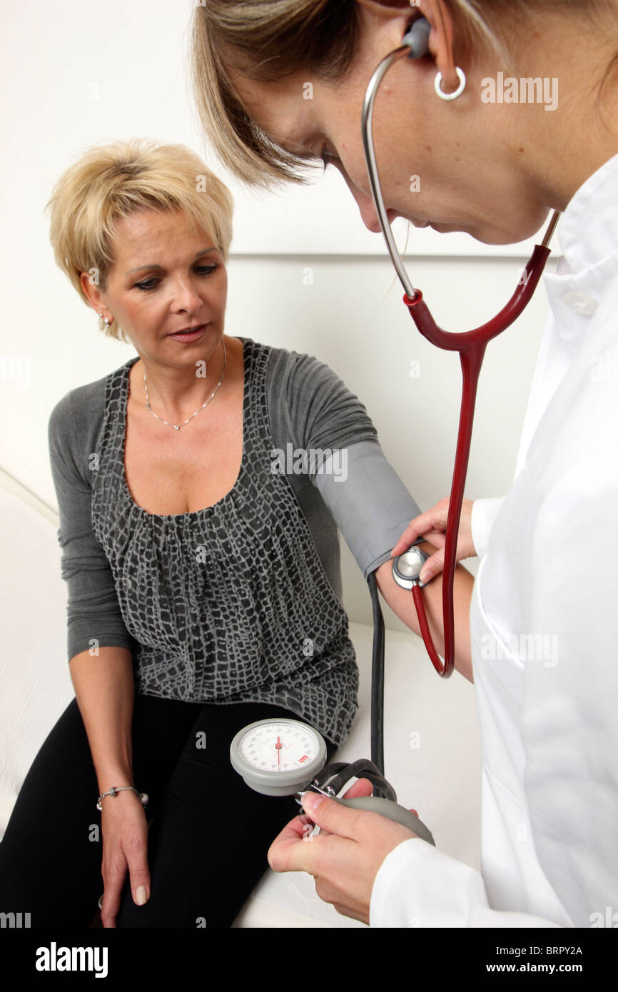 Medical practice, taking the blood pressure of a patient Stock Photo