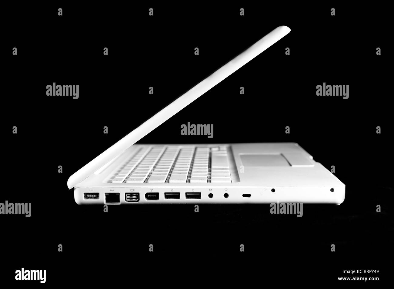 Apple Macbook laptop (white), half way open against black Stock Photo