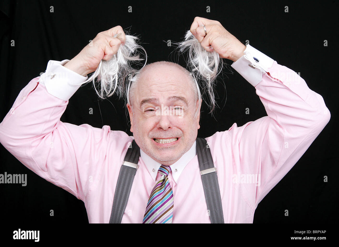 stressed out business man pulling his hair from his head frustrated and angry Stock Photo