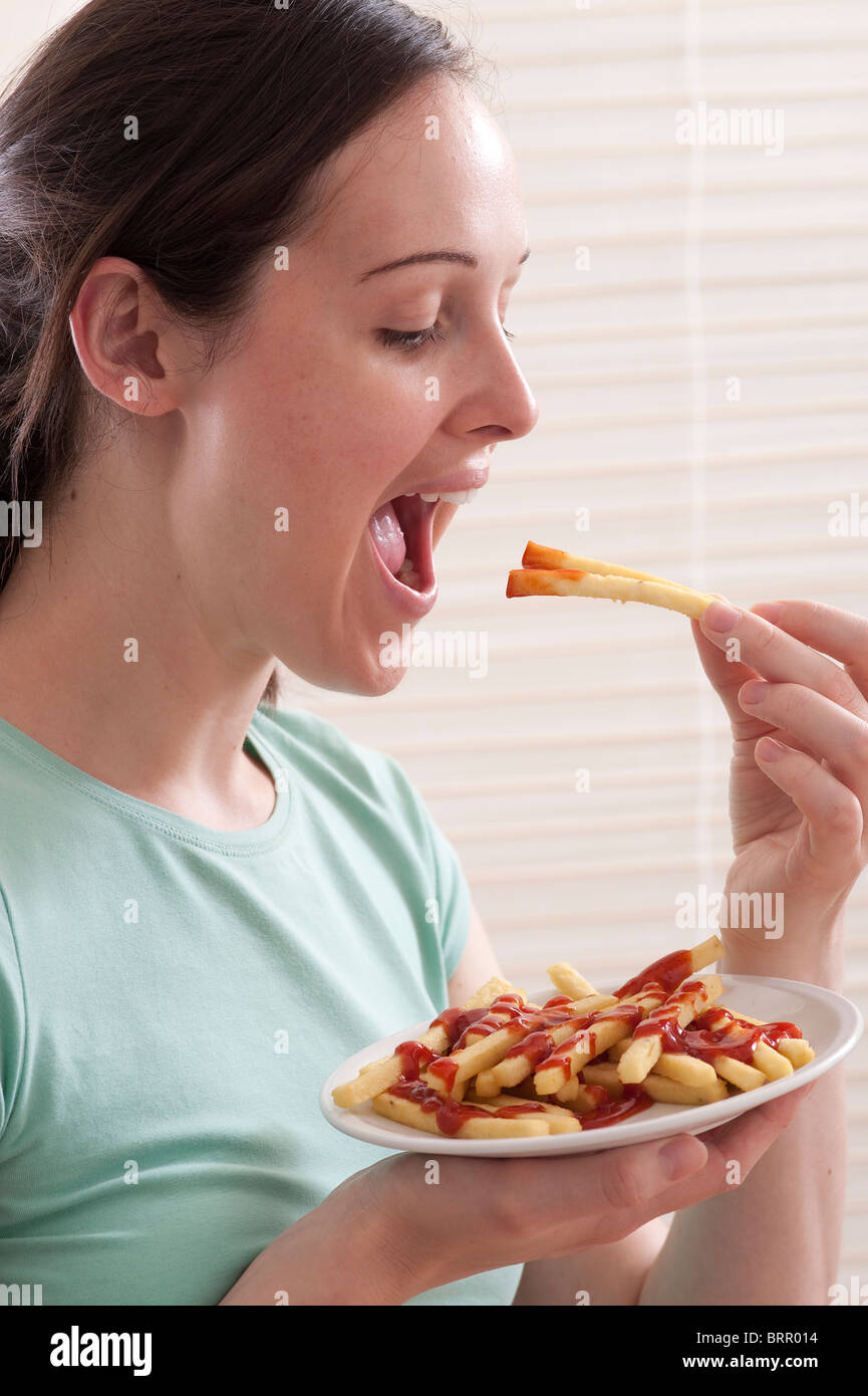 young woman eating french fries and ketchup Stock Photo Alamy