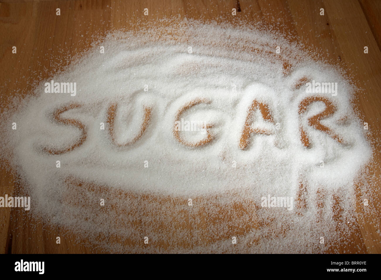 sugar spelt out with spilled pile of granulated sugar Stock Photo