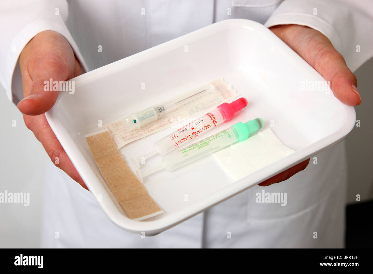 Medical practice. Doctors assistant  taking a blood sample of a patient. tray with needle and drain tube. Stock Photo