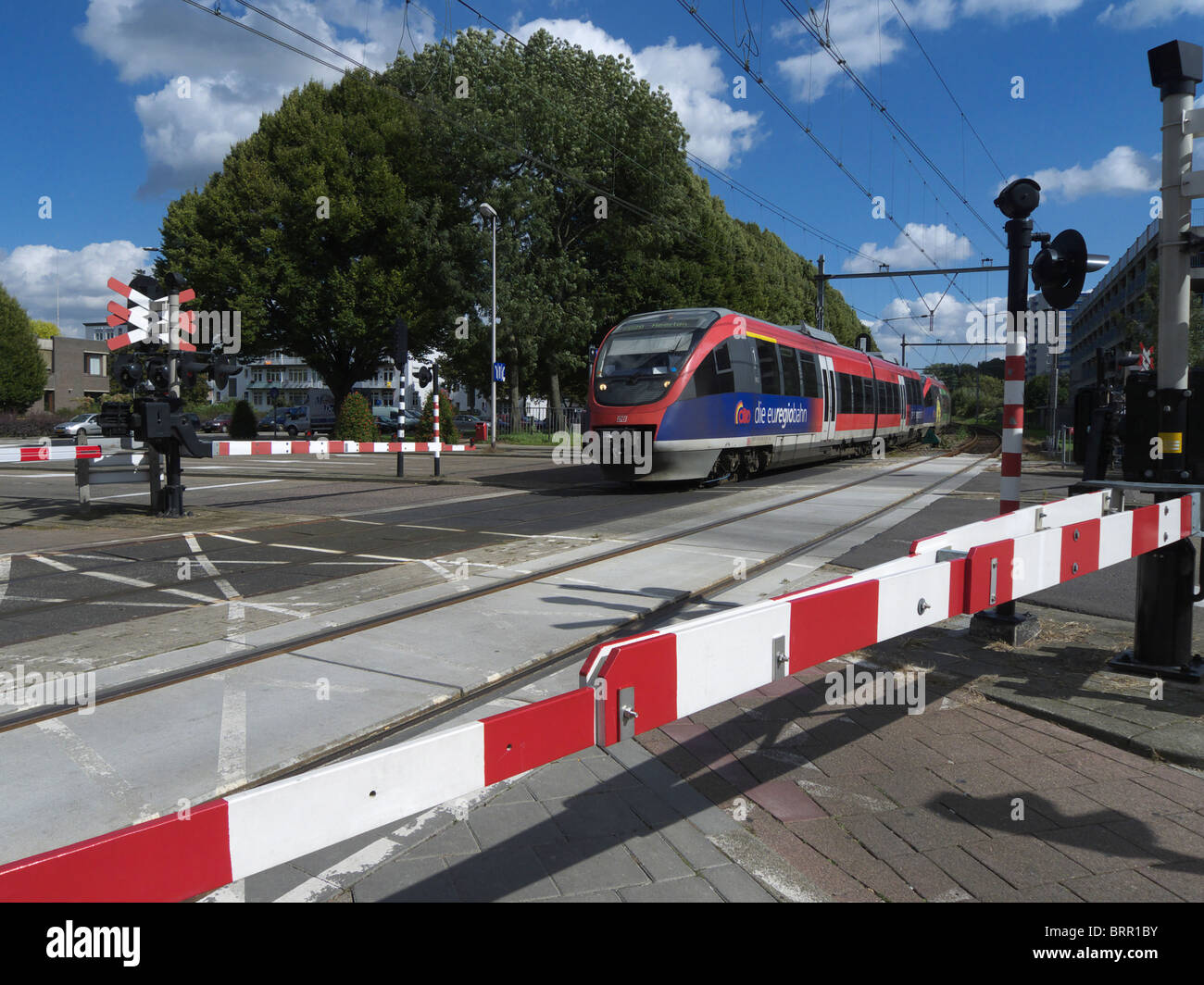 A train about to pass over a level crossing in Heerlen, The Netherlands. Stock Photo