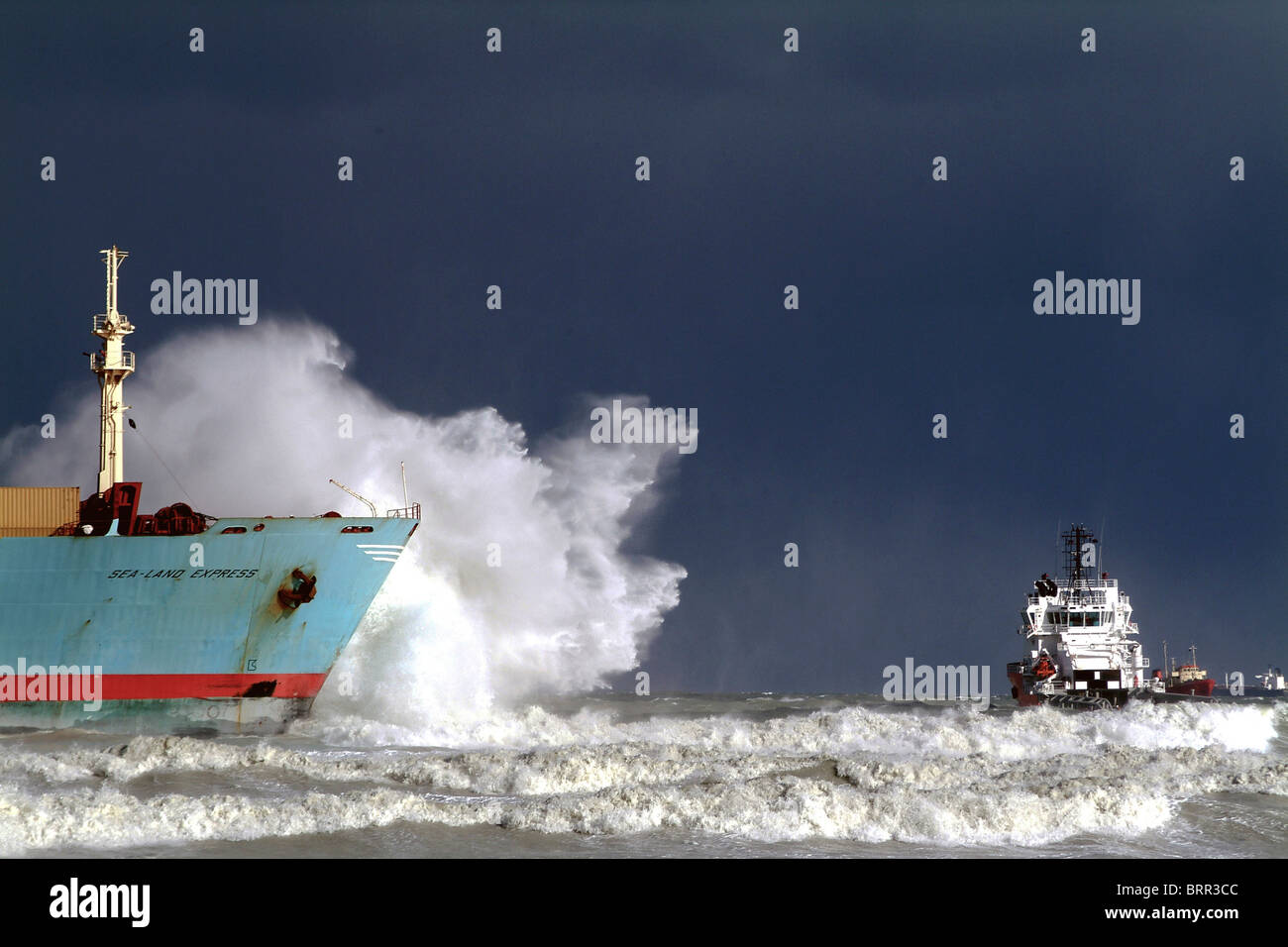 Ships hull spraying sea surf in shallow water Stock Photo
