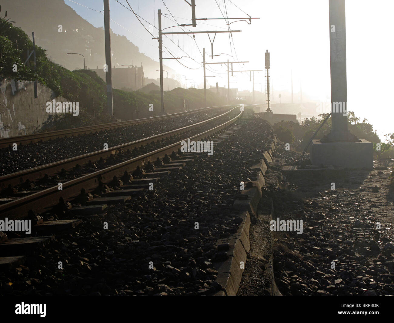 Railway lines and overhead cables on a misty morning Stock Photo