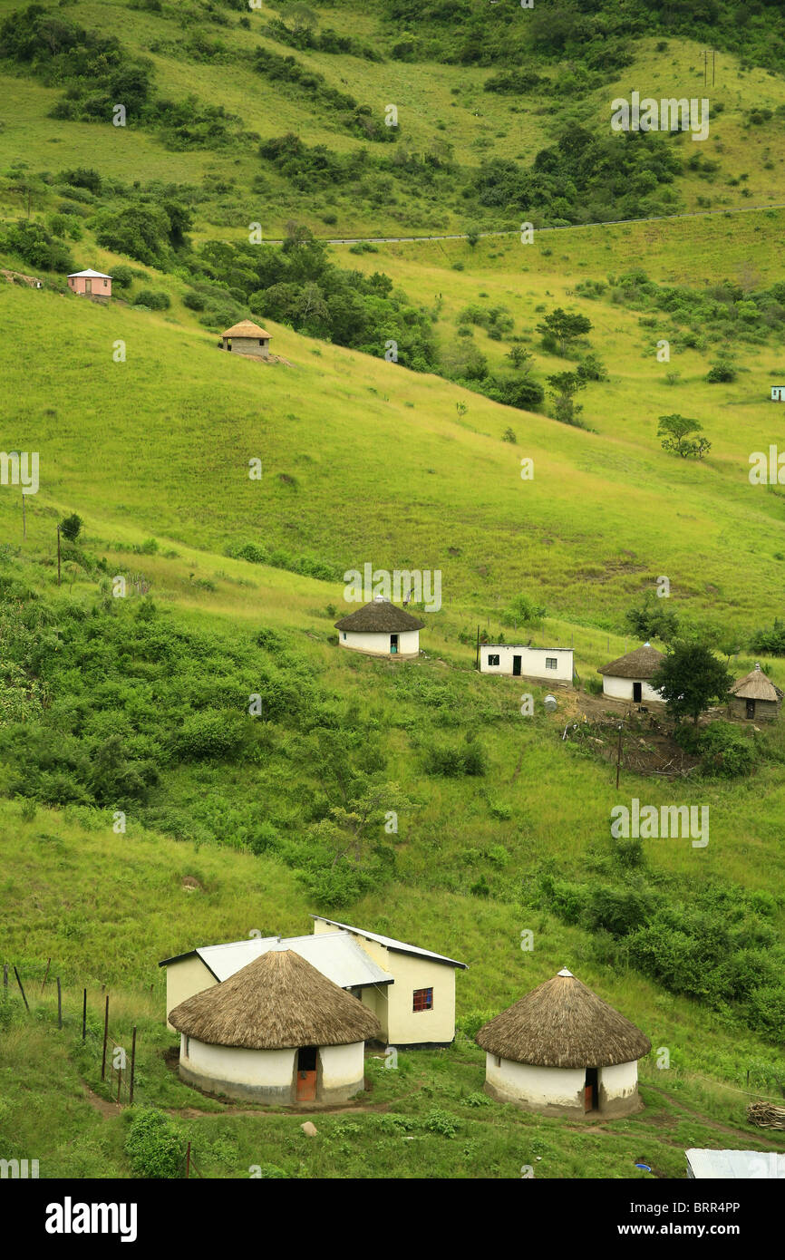 Rural landscape with green hills and scattered mud and thatch huts Stock Photo