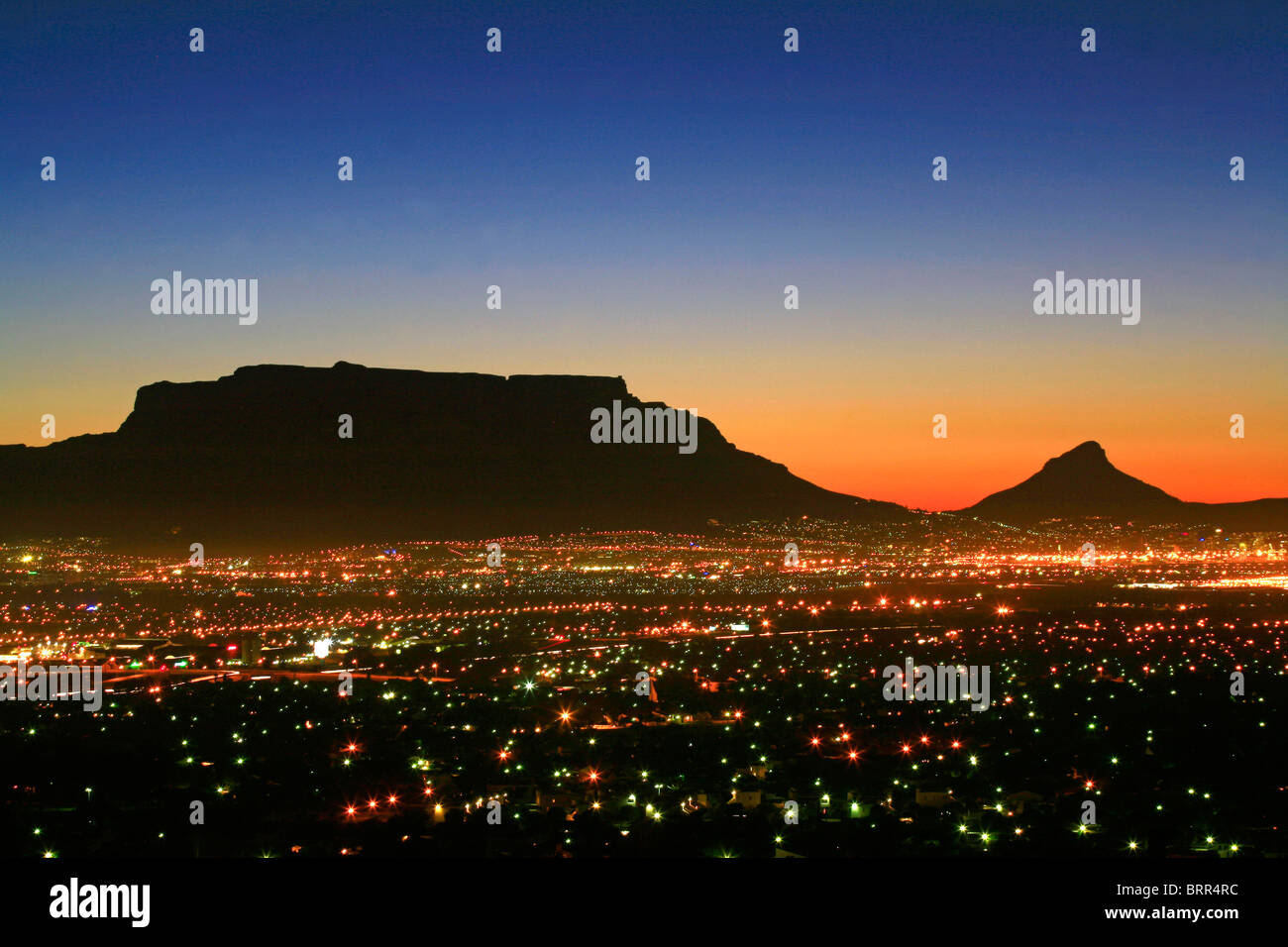 View over Cape Town city lights at sunset with Table Mountain and Lions Head in the background Stock Photo