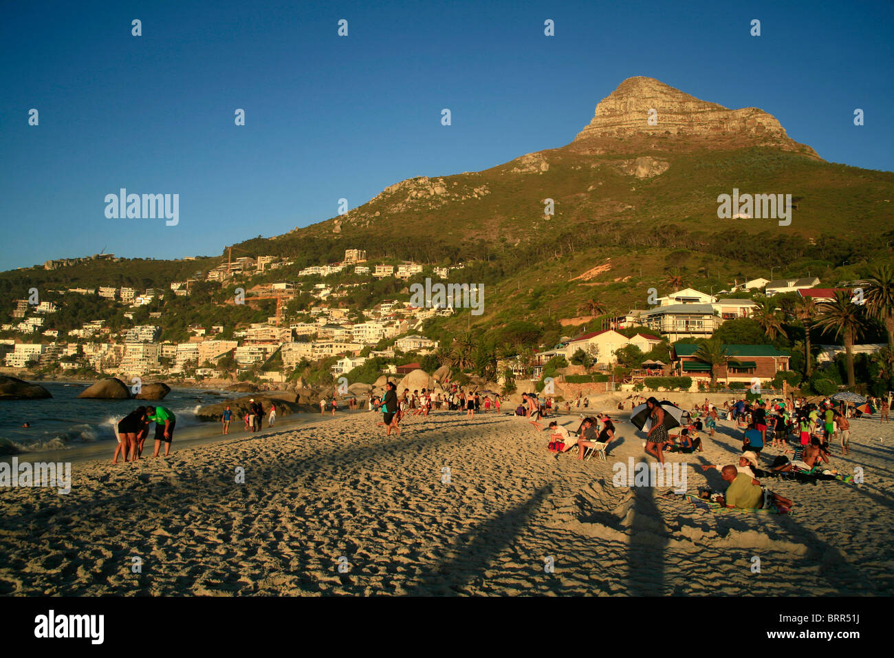 People relaxing on Clifton's fourth beach at sunset, Lions Head in the background Stock Photo