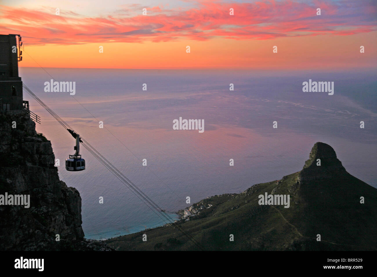 Cable car to Table Mountain at sunset, with Atlantic Ocean and Lions Head in the background Stock Photo