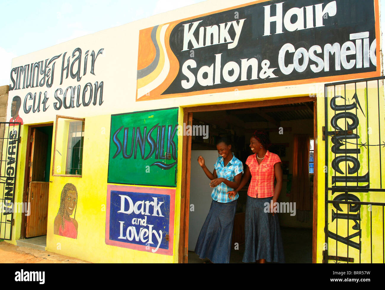 Two woman laughing in the doorway of a rural hair dressing salon Stock Photo Alamy