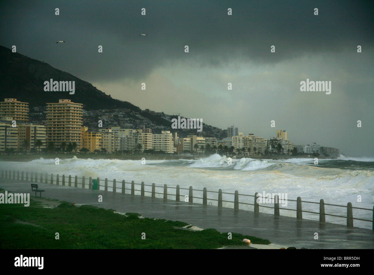 View over Sea Point with storm clouds overhead and rough sea. Stock Photo