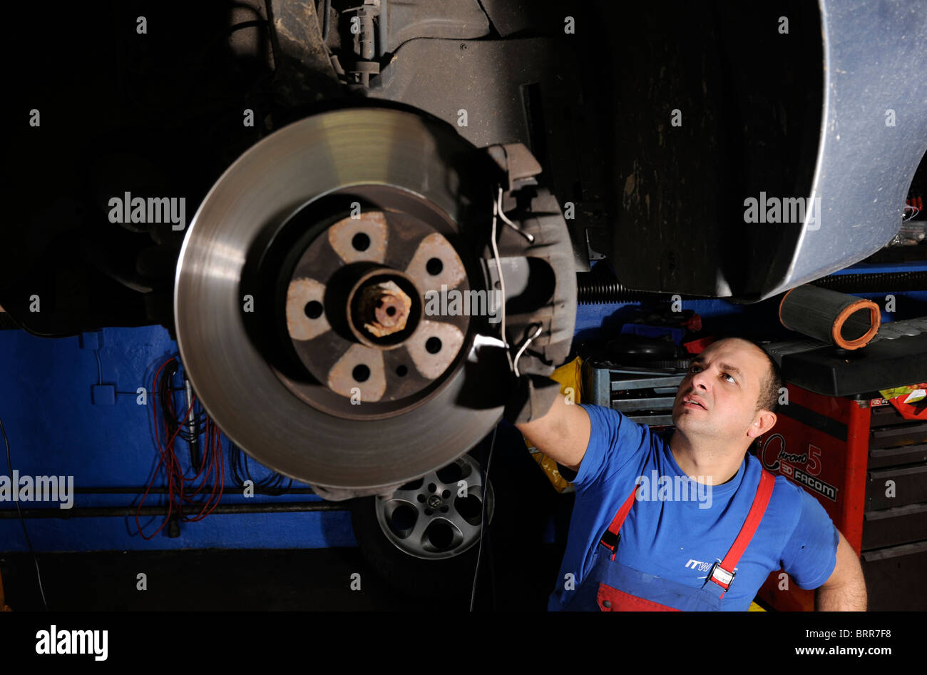 Car workshop with mechanic at work. Stock Photo