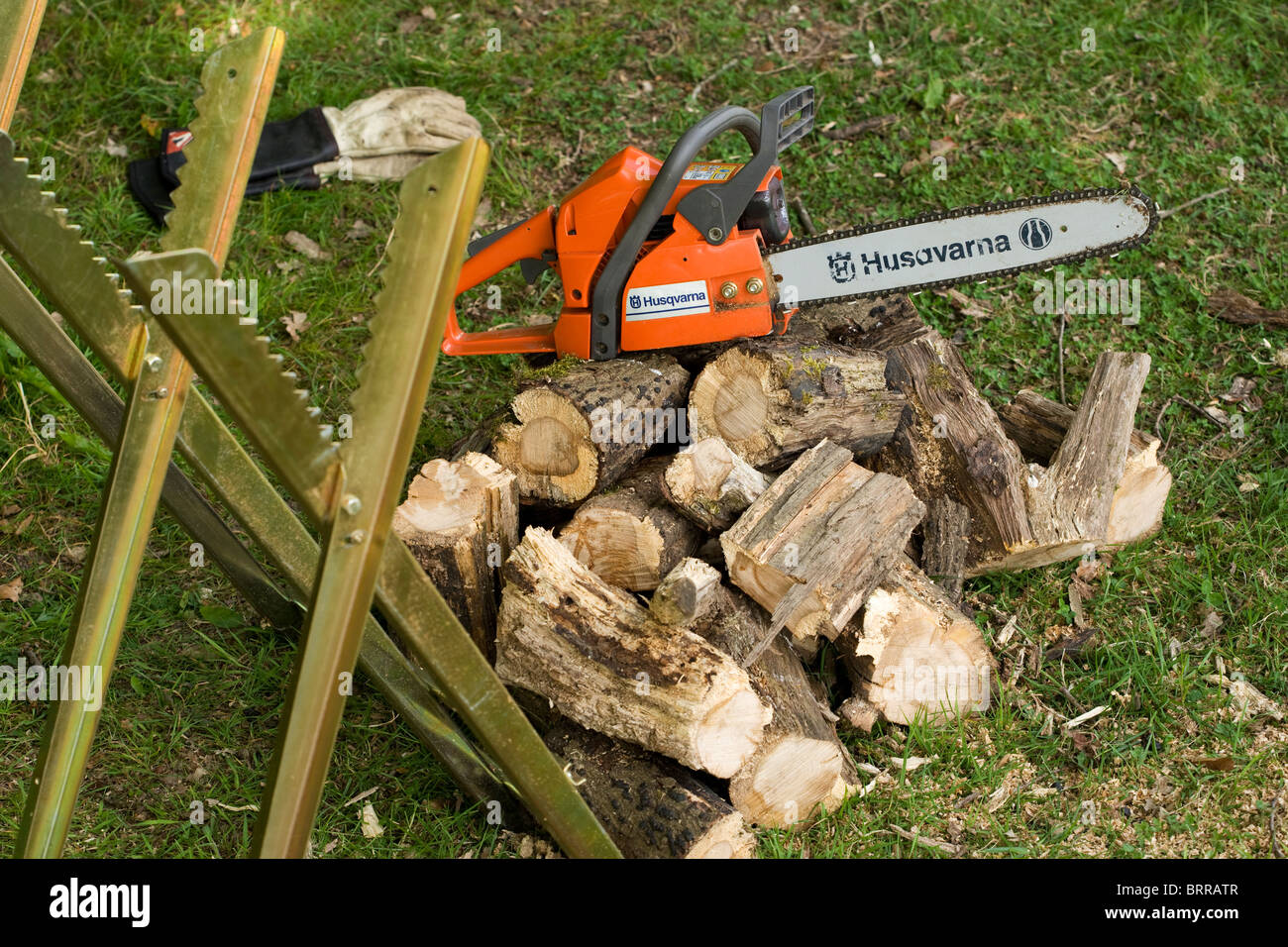 Chainsaw , saw horse, gloves and sawn logs Stock Photo