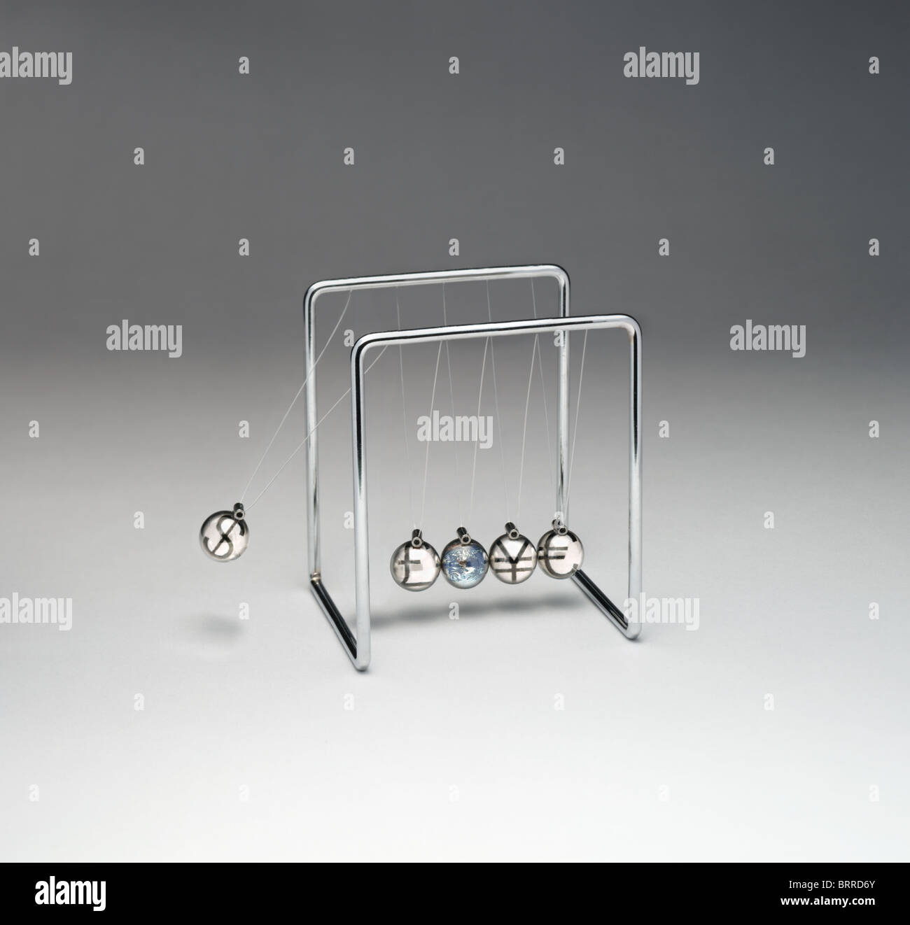 Newton's Cradle with currency symbols Stock Photo
