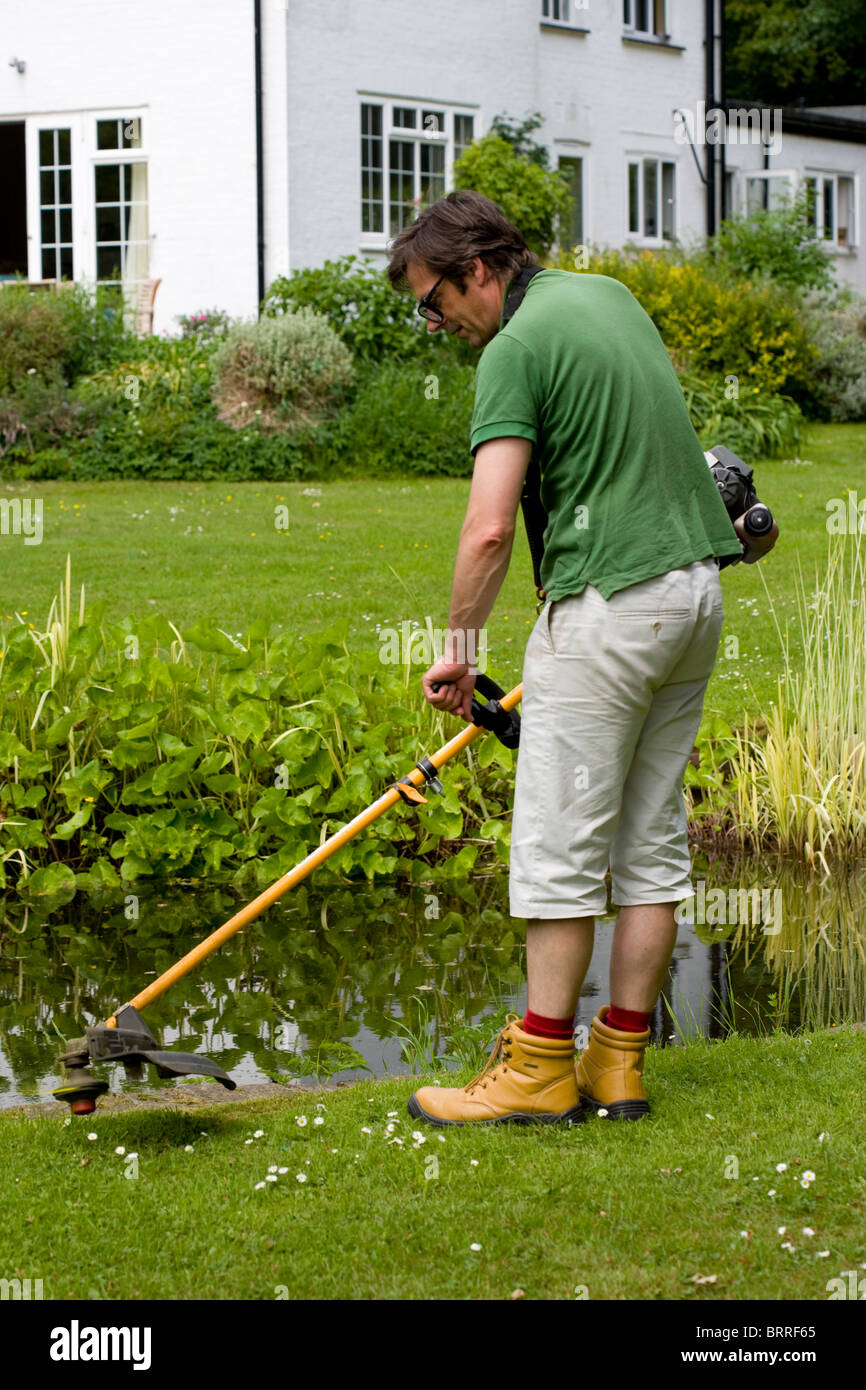 man using a strimmer in the garden Stock Photo