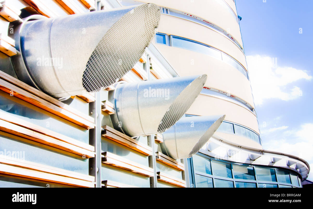 High Contrast abstract view of stainless steel ducts exiting modern building. Stock Photo
