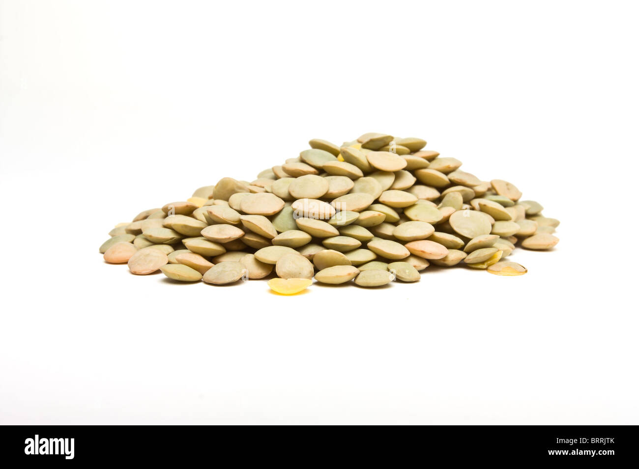 Pile of green lentils from low perspective isolated on white. Stock Photo