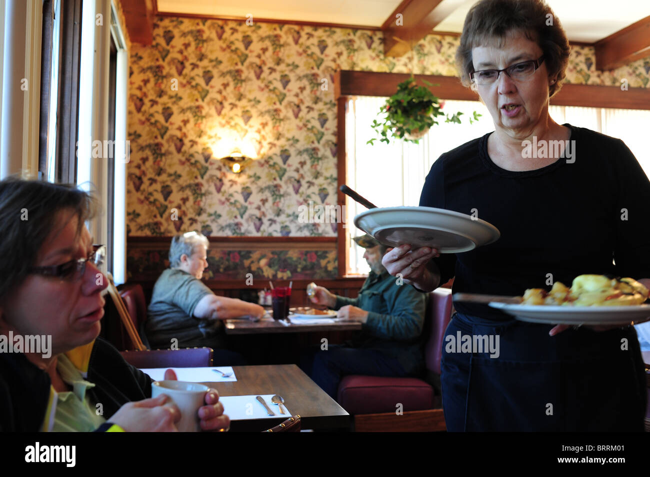 USA New York Naples NY Finger Lakes Region waitress serving breakfast at The Redwood Restaurant Stock Photo