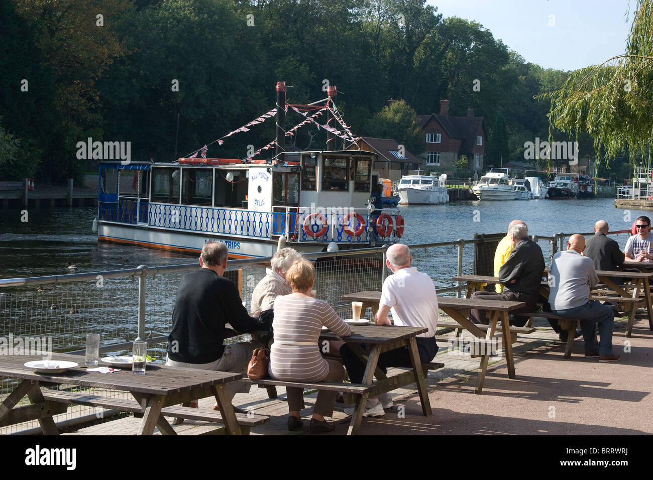 pub river side bank drinkers boat paddle tables Stock Photo