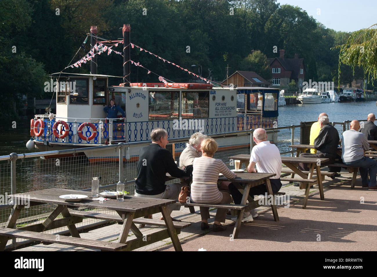 pub river side bank drinkers boat paddle tables Stock Photo