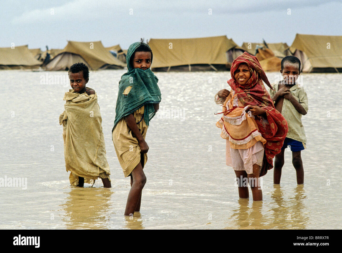 Famine in the Darfur region of the Sudan, 1985. Children play in water after unseasonable heavy rains at Mawashi refugee camp. Stock Photo