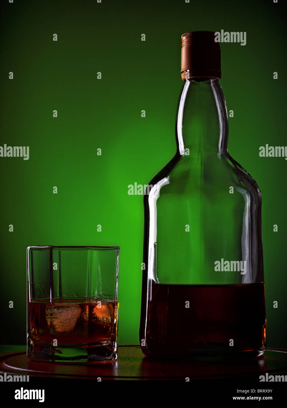 whiskey and glass on wooden tray, green background Stock Photo Alamy