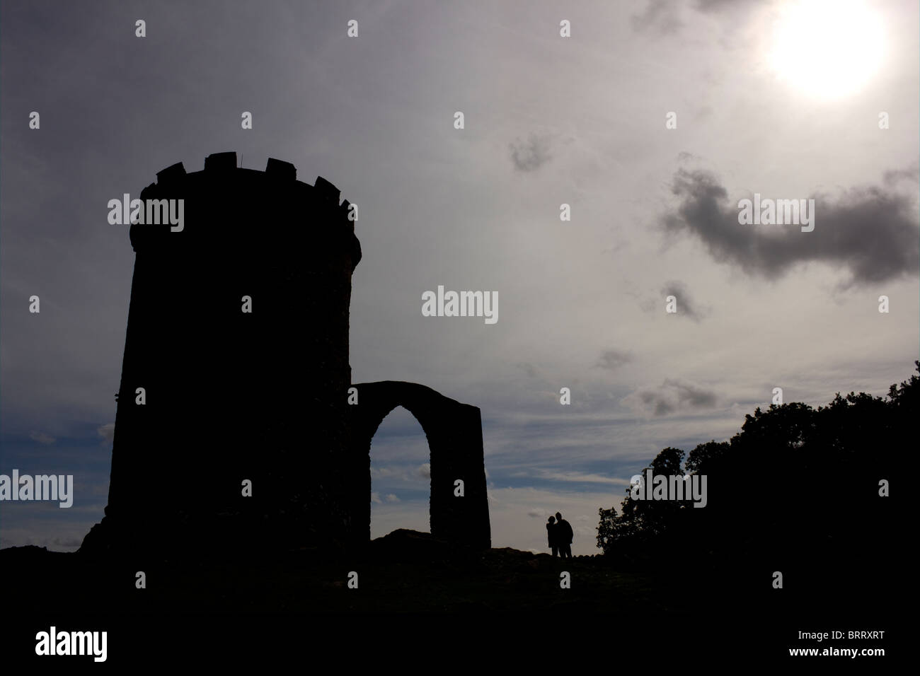 Sunlit silhouette of Old John and couple, Bradgate Park, Cropston, Leicestershire, England, UK Stock Photo