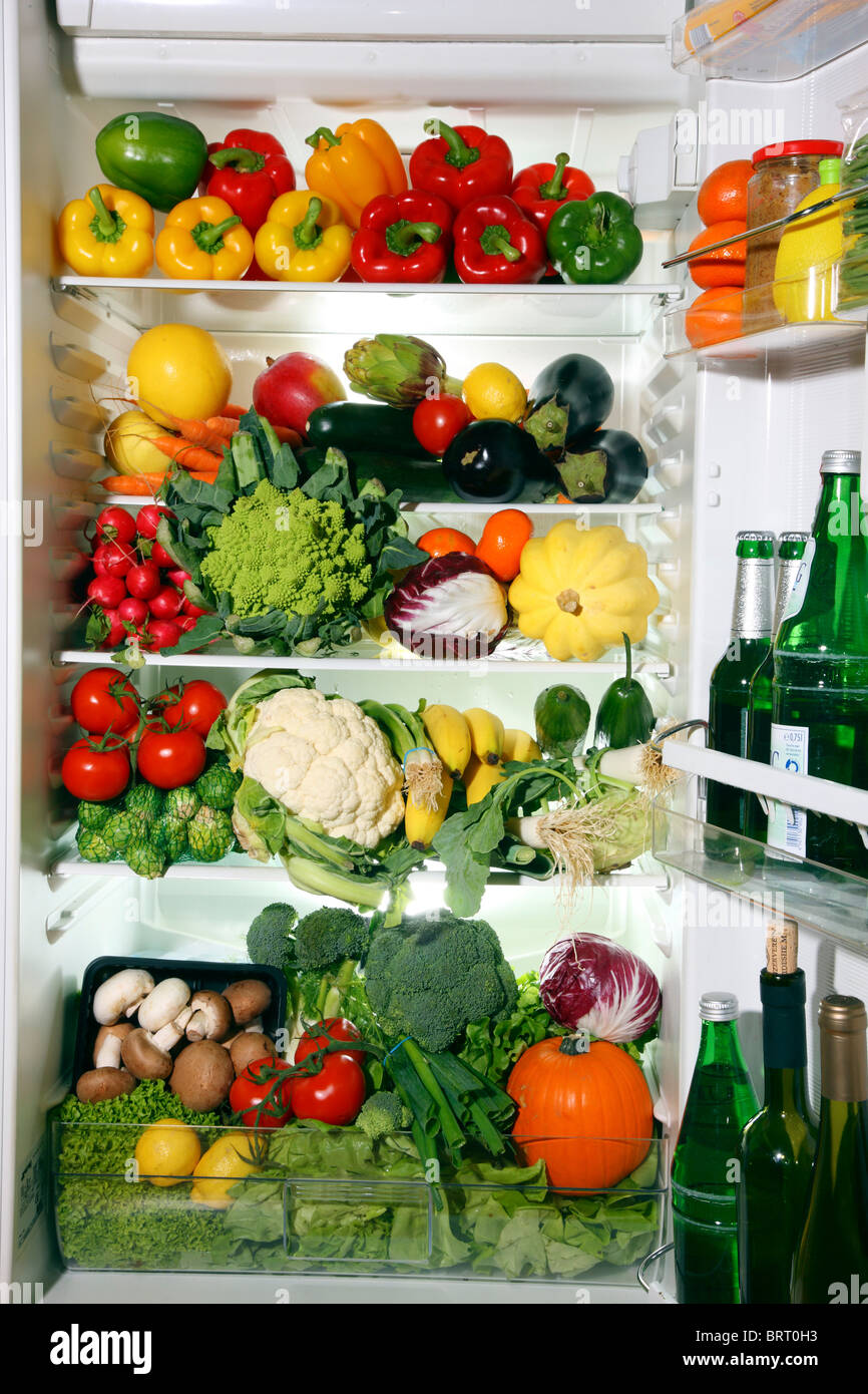 Refrigerator filled with many different vegetables, fruits, salads