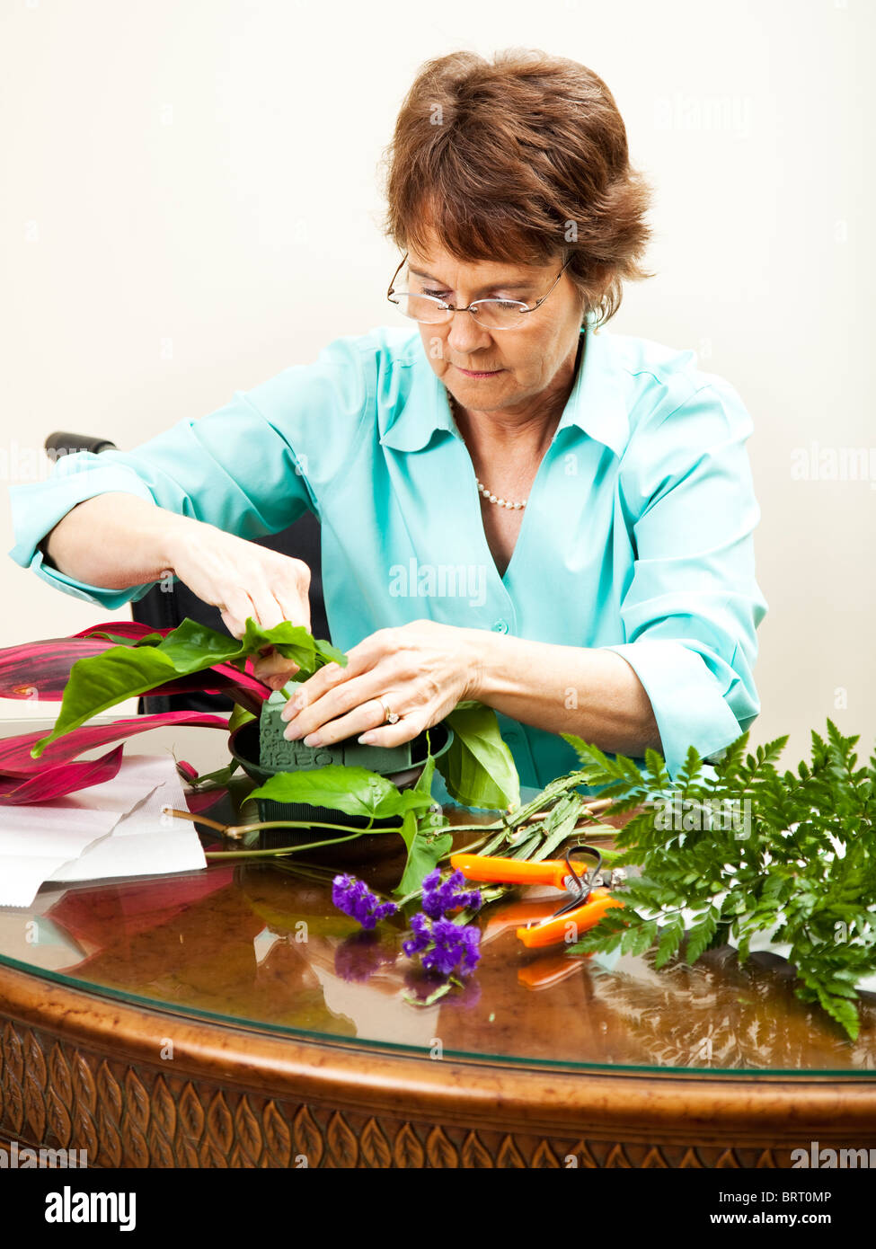 Disabled florist in wheelchair, creating a flower arrangement Stock ...