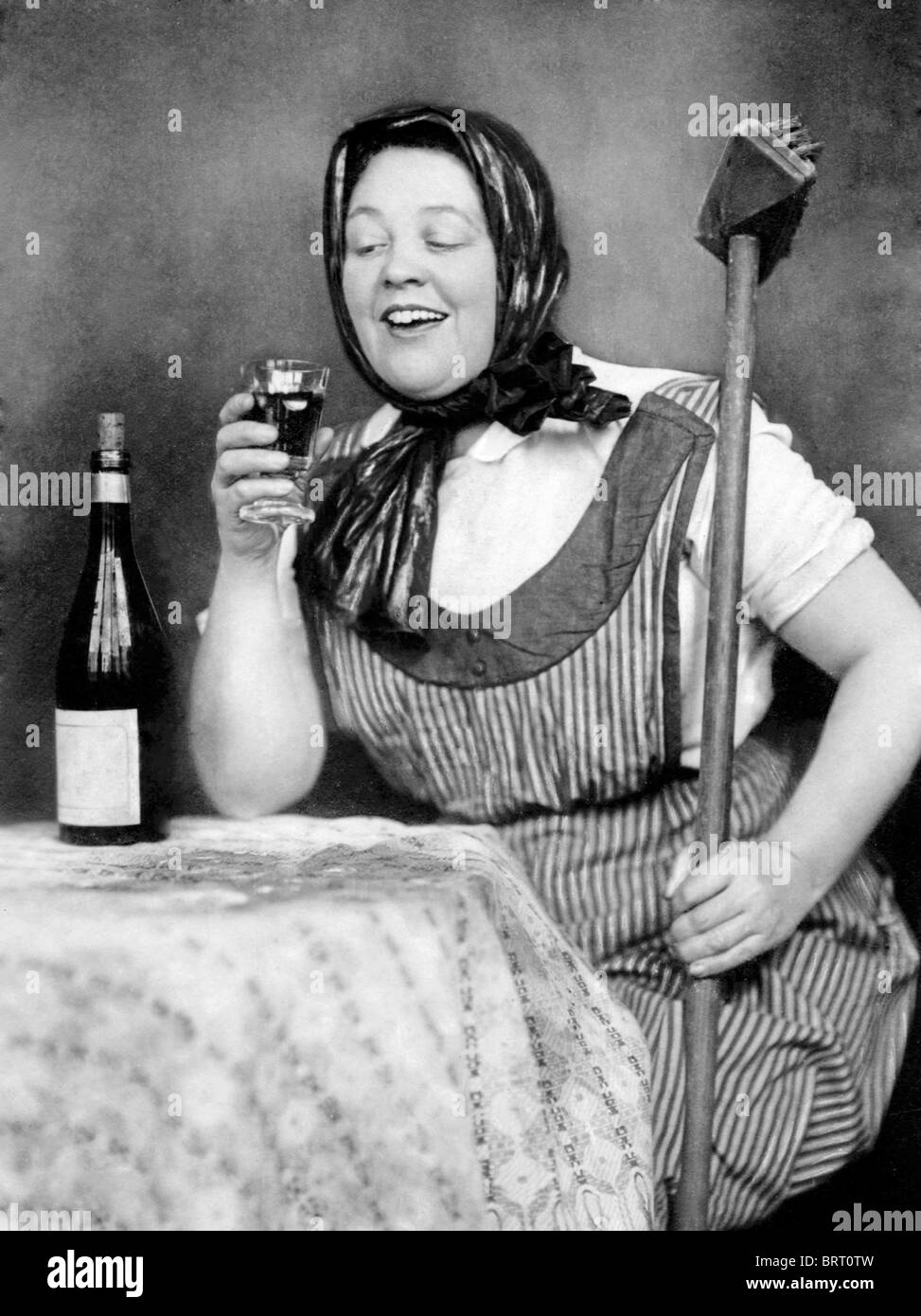 Cleaning lady drinking wine, historic photograph, around 1930 Stock Photo