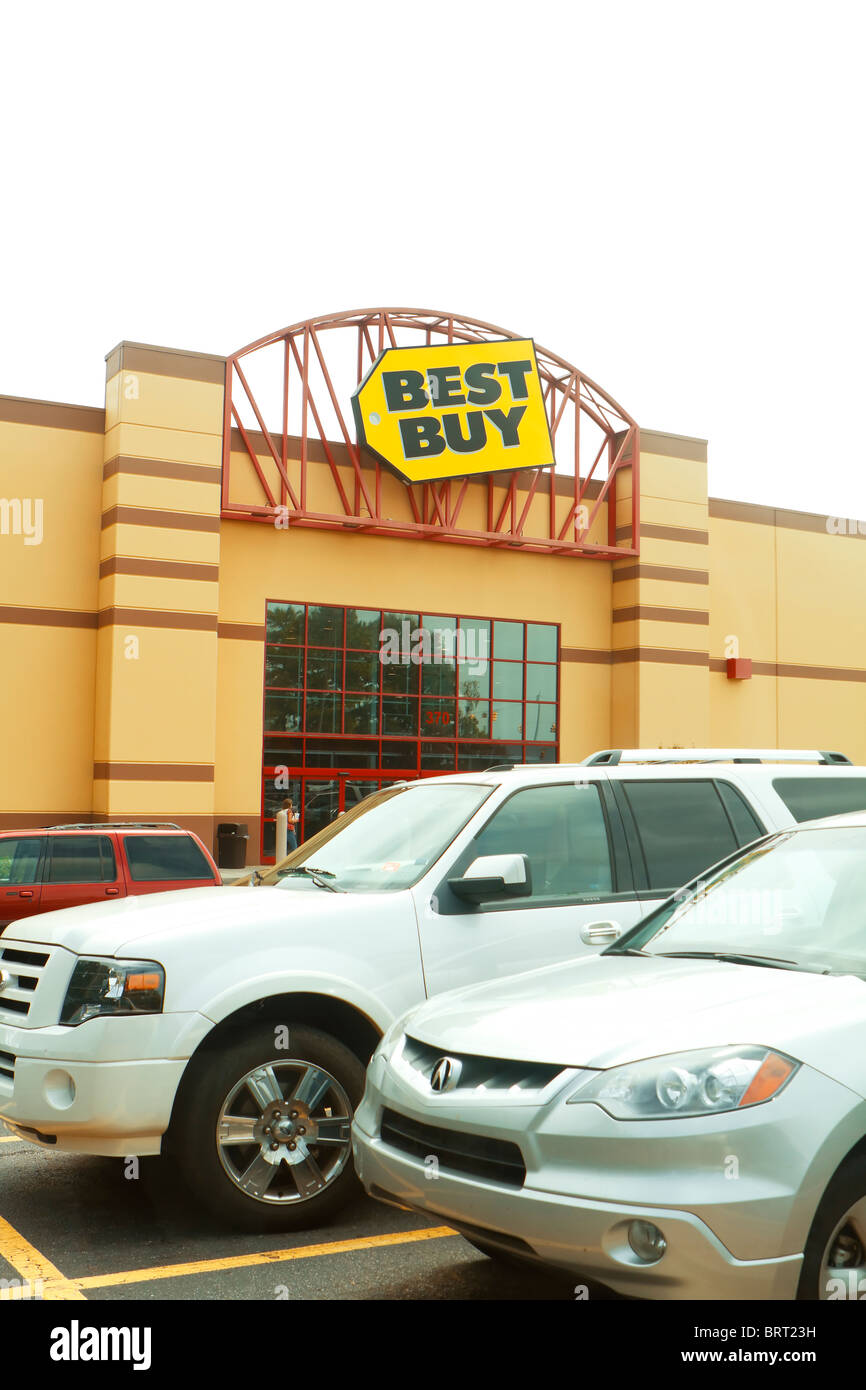 The front entrance and logo sign for a Best Buy retail electronics store on a cloudy  overcast day. Stock Photo