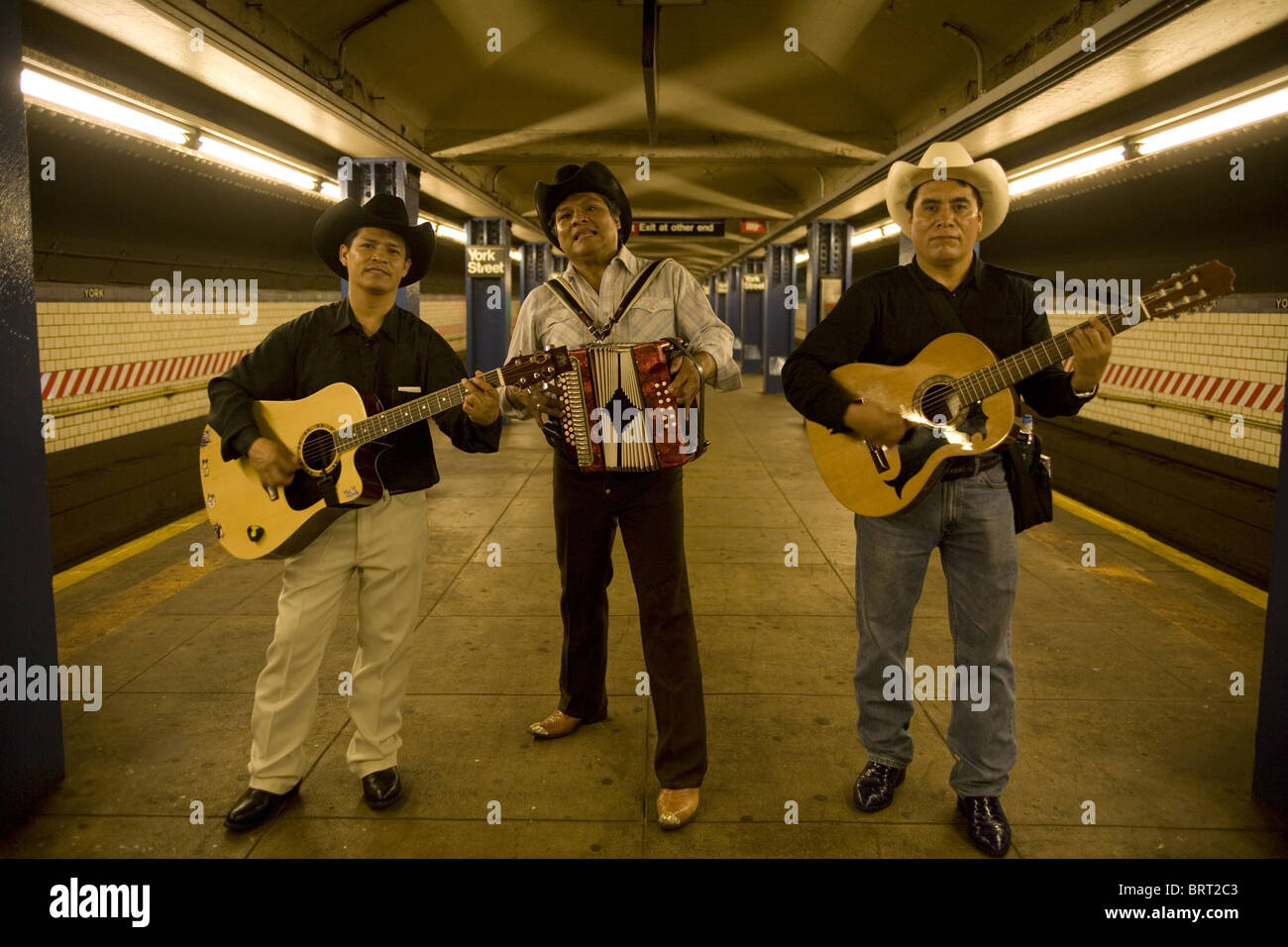 Professional quality Mexican musical group plays music on the NYC subways for tips. Waiting for the train, York Street stop Stock Photo