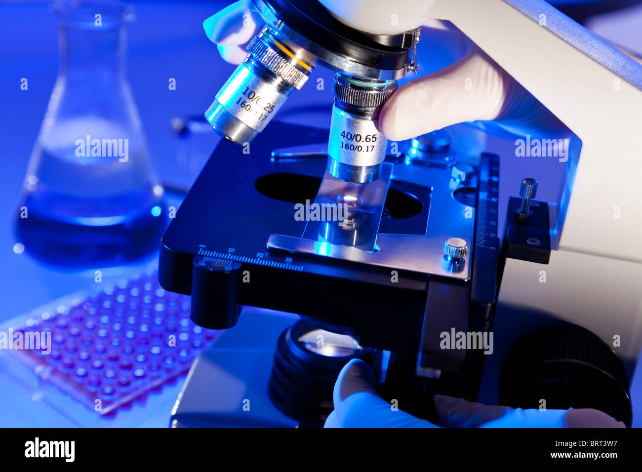 A medical or scientific researcher using a microscope in a laboratory ...