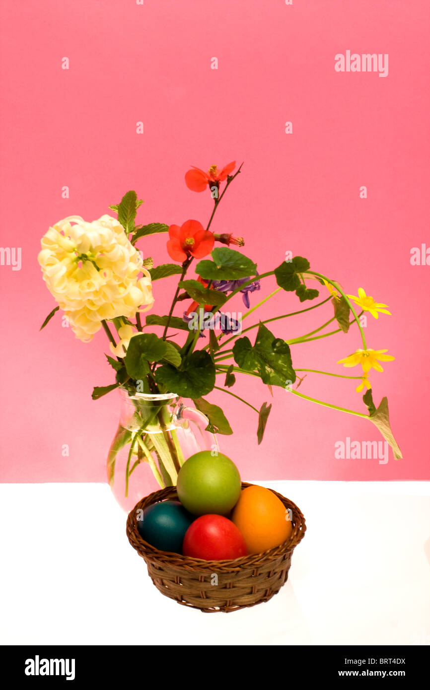 A traditional Easter still life with colored eggs and spring flowers ...
