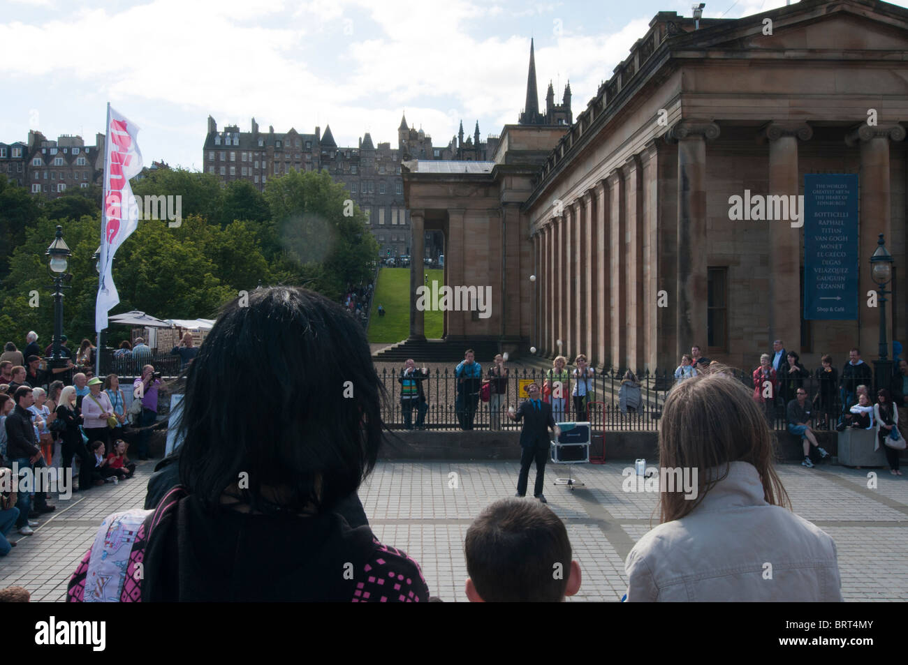 Edinburgh Fringe street performer at the National Museums of Scotland with the Old Town in the background Stock Photo