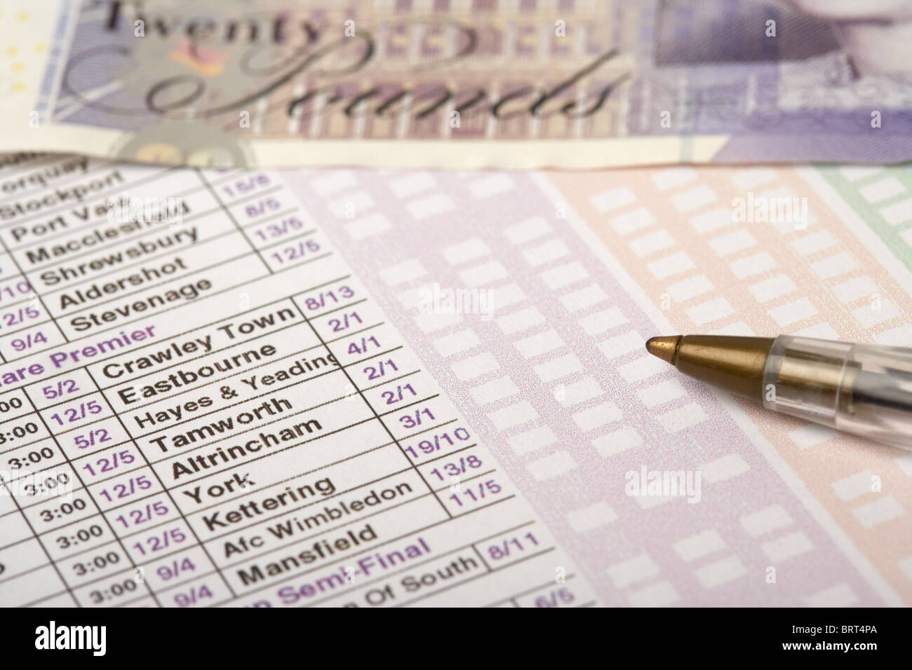 football betting slip from a bookmakers with pen and twenty pound note Stock Photo