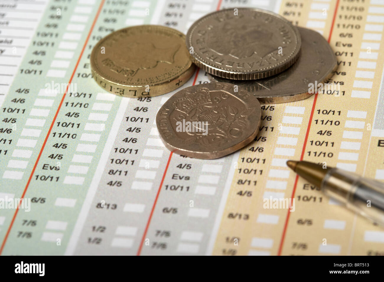 betting slip from a bookmakers showing the odds with british coins cash