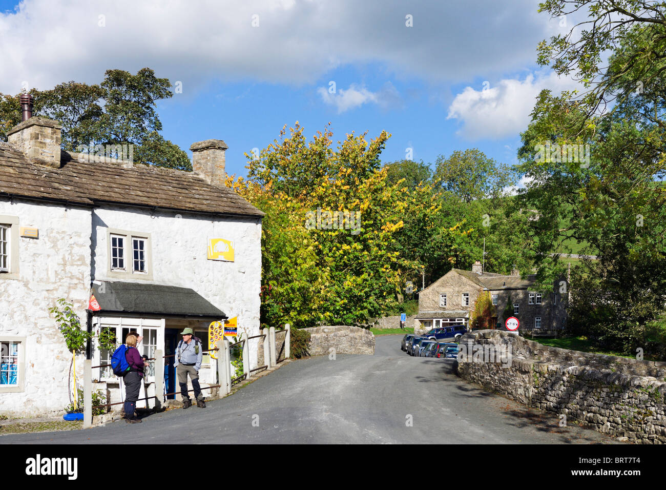 Walkers outside the village shop in the centre of Malham, Wharfedale, Yorkshire Dales, England, UK Stock Photo