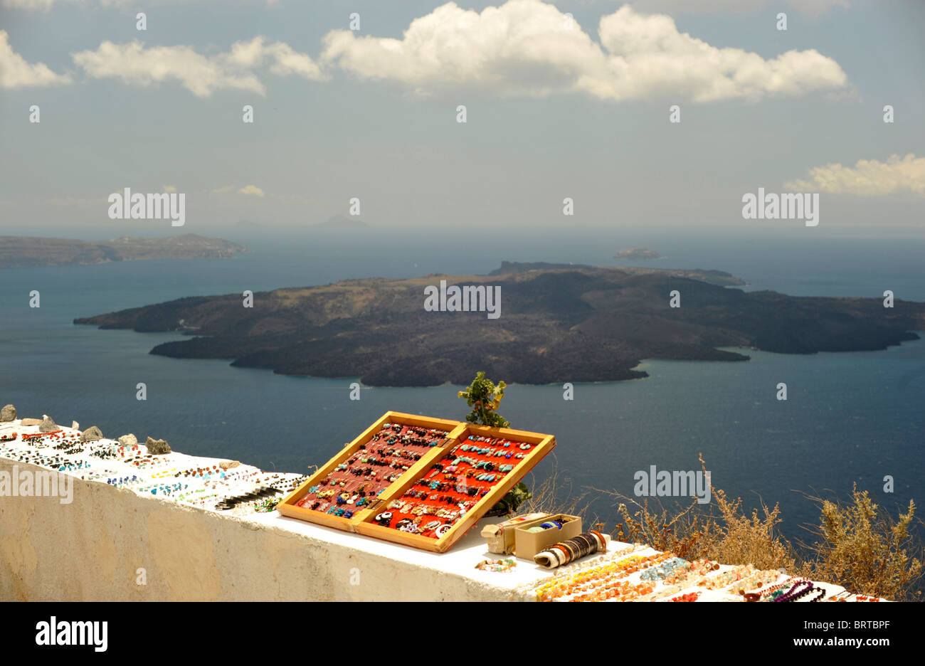 A selection of tourist souvenirs, jewelry on a wall overlooking the Caldera on the Greek island of Santorini Stock Photo