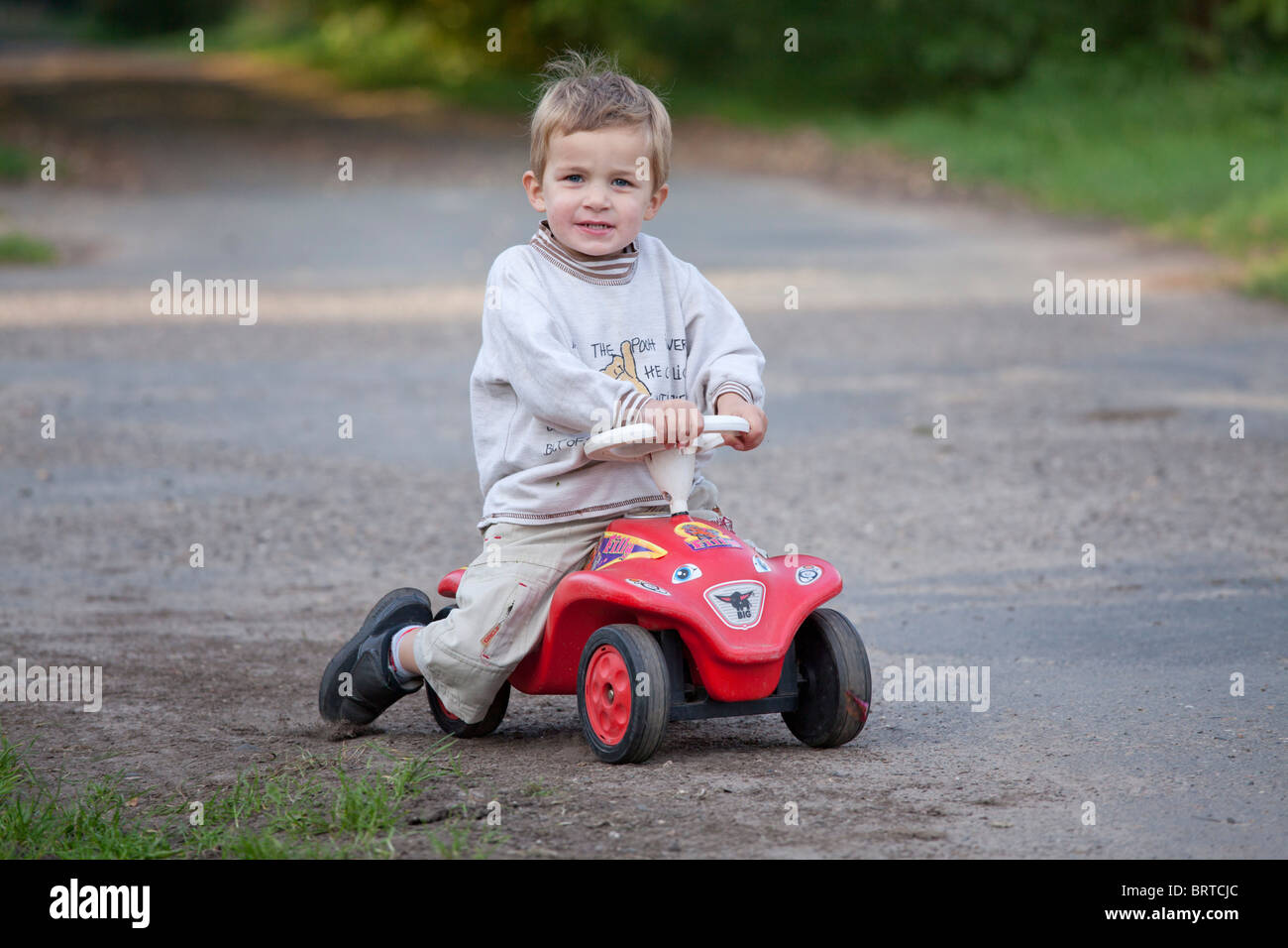 portrait of a little boy on his bobby car Stock Photo