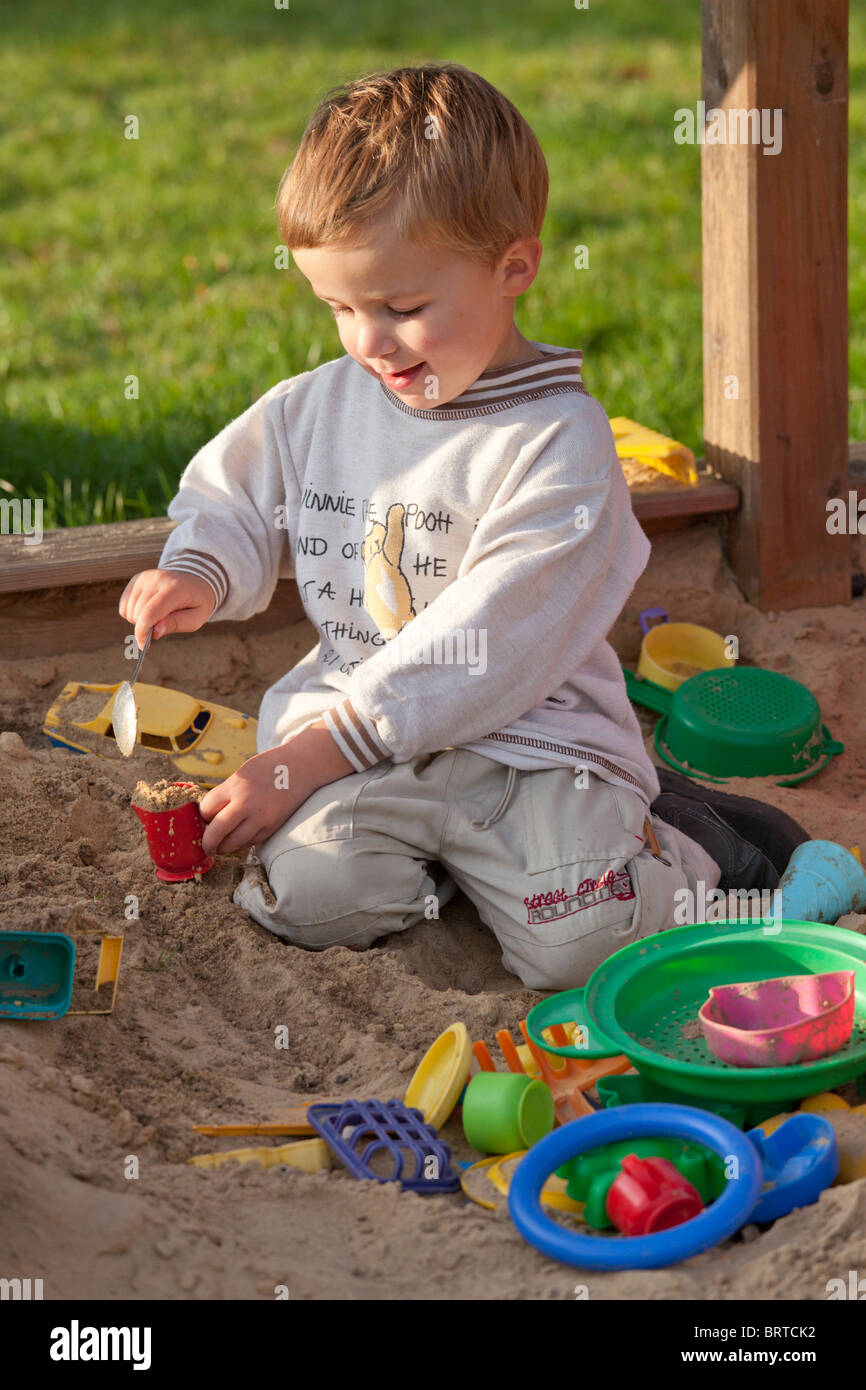 portrait of a little boy playing in a sandpit Stock Photo