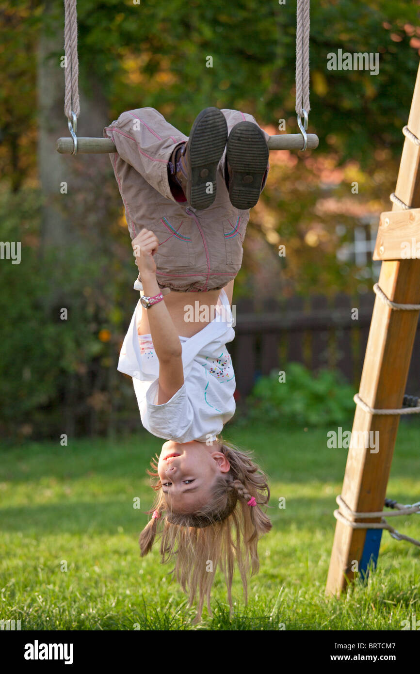 little girl dangling head first on a swing Stock Photo