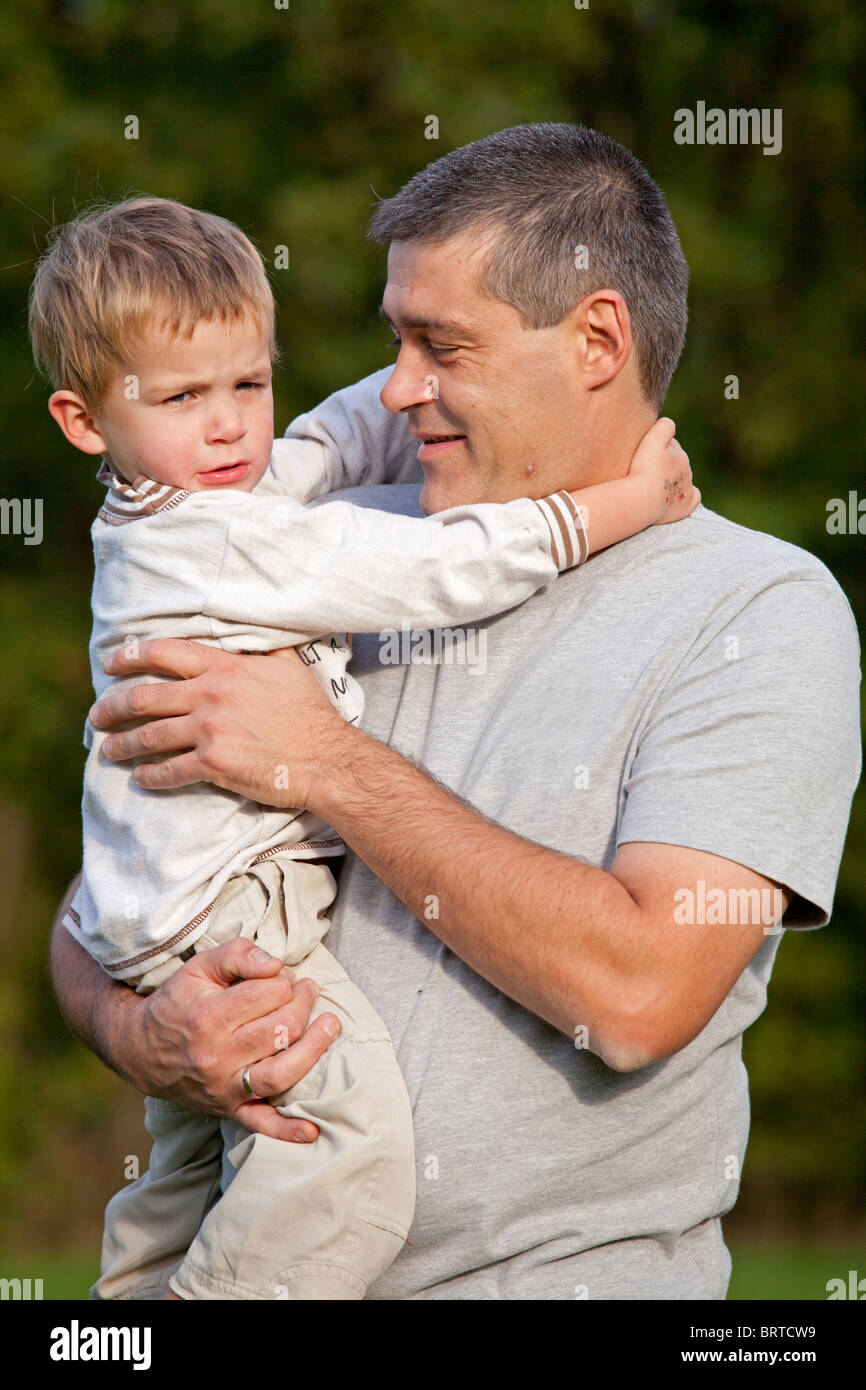 A father holding his young son in his arms stock photo  alamy