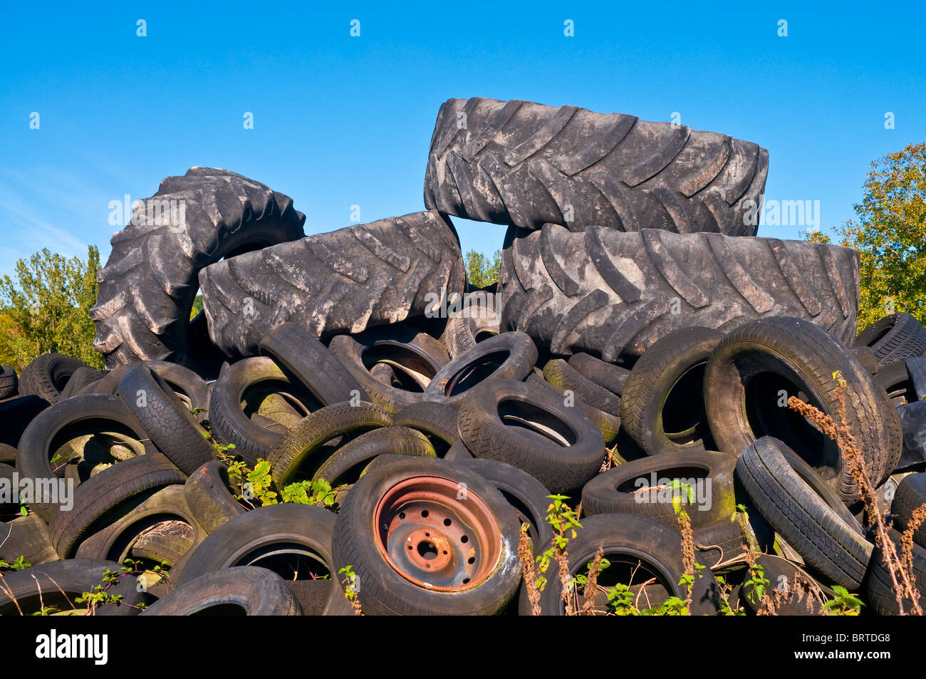 Roadside dump of old vehicle and tractor tires - France. Stock Photo