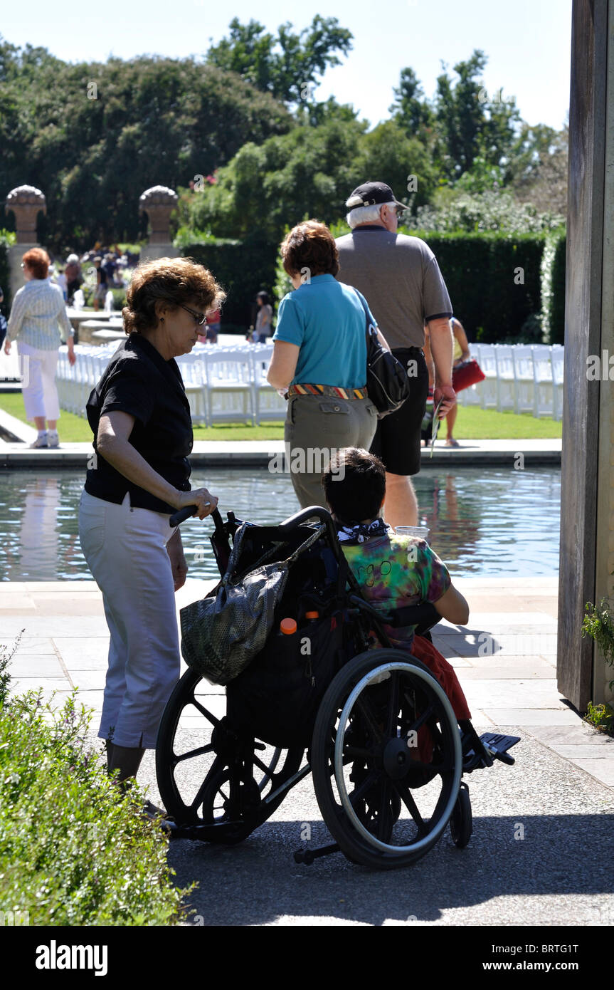 Woman with disabled child in wheelchair, visiting Dallas Arboretum